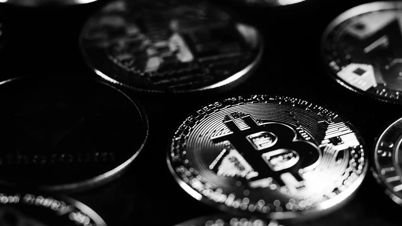 Digital asset coins photographed in black and white.